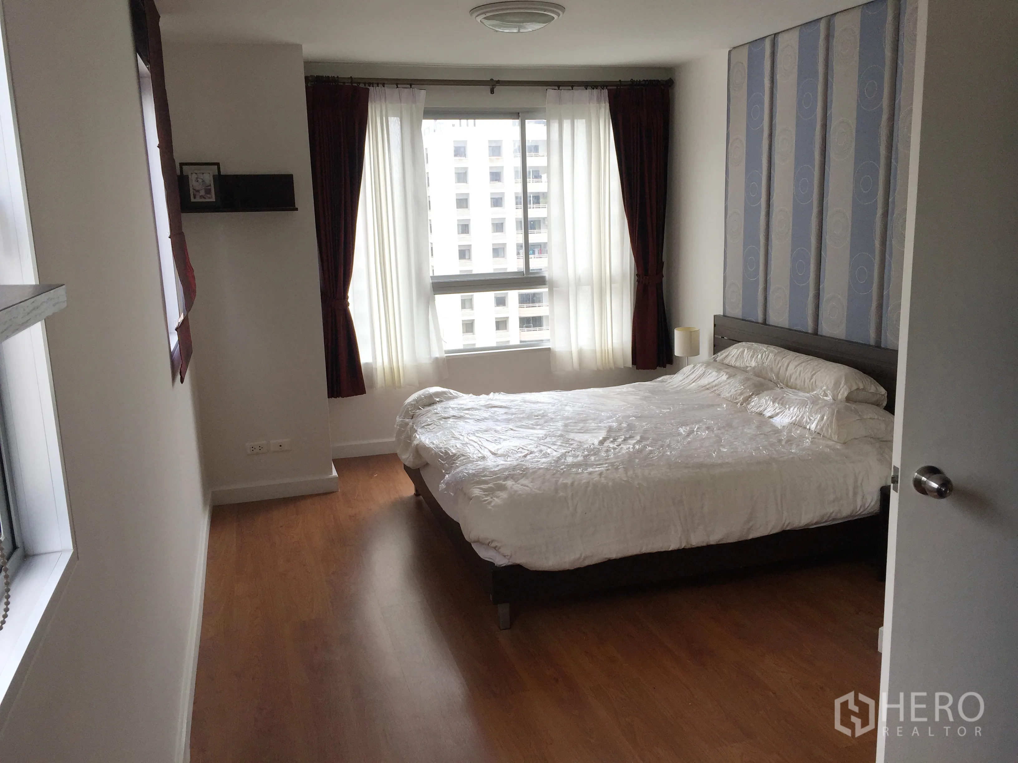 คอนโด ให้เช่าในKhlong Toei, Bangkok - ห้องนอนเตียงคู่ หน้าต่างบานใหญ่พร้อมผ้าม่าน พื้นไม้ และวิวเมือง