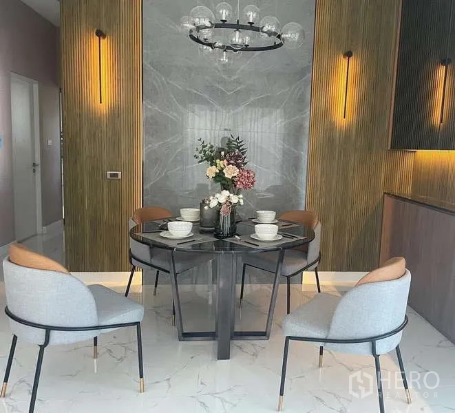 Detached House for rent in Bang Phli, Samut Prakan - Round dining table set for four with gray marble accent wall and warm sconces.