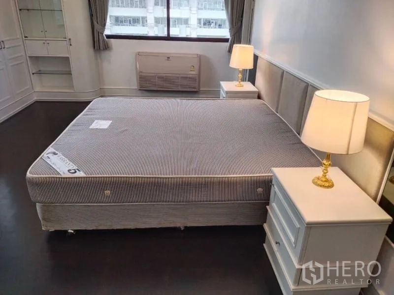 公寓 出租在Sathon, Bangkok - 主卧配备特大床、床头柜与台灯，并有大窗户。