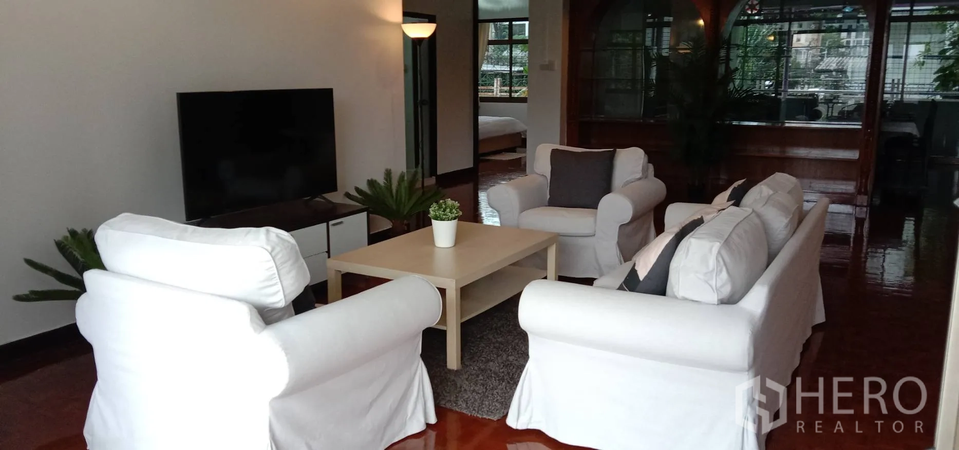 อพาร์ทเมนท์ ให้เช่าในRatchathewi, Bangkok - ห้องนั่งเล่นสว่าง โซฟาสีขาว ทีวี และพื้นไม้ขัดเงา