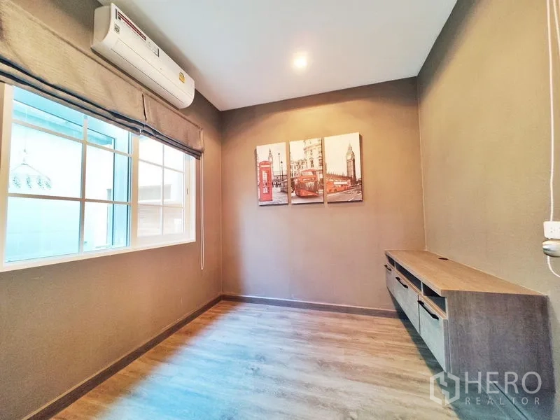 联排别墅 出租或出售在Phra Pradaeng, Samut Prakan - 温馨书房或卧室，空调、深色墙面与内置矮柜。