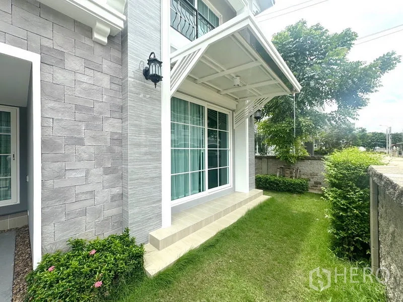 บ้าน ให้เช่า - ด้านข้างบ้านมีประตูกระจกบานเลื่อน ผนังลายหิน และสวนหย่อม