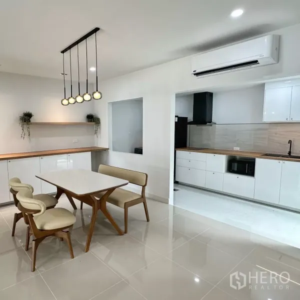 Townhouse for rent in Bang Phli, Samut Prakan - Dining area with pendant lights looking toward the built-in white kitchen and counter.