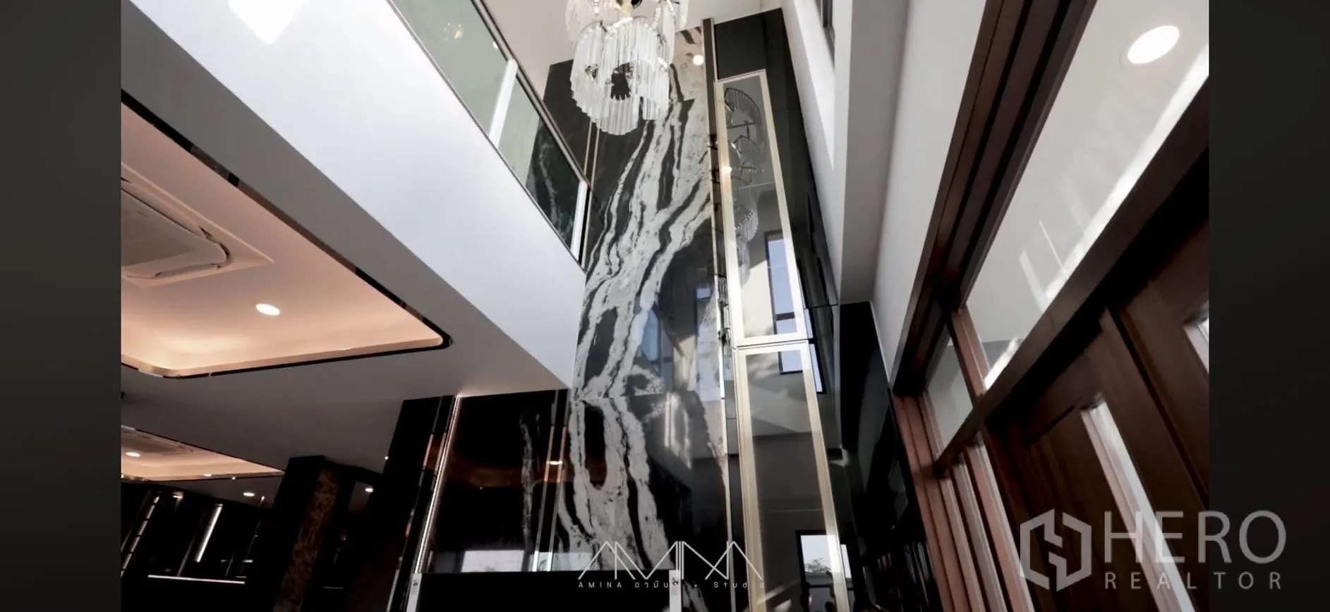 Detached House for rent in Saphan Sung, Bangkok - Double-height foyer with chandelier and towering marble feature wall.