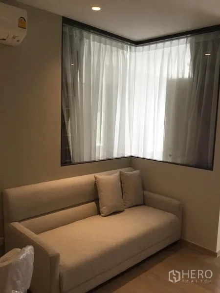 公寓 出租在Watthana, Bangkok - 转角沙发与纱帘玻璃隔断的客厅一角，氛围温馨