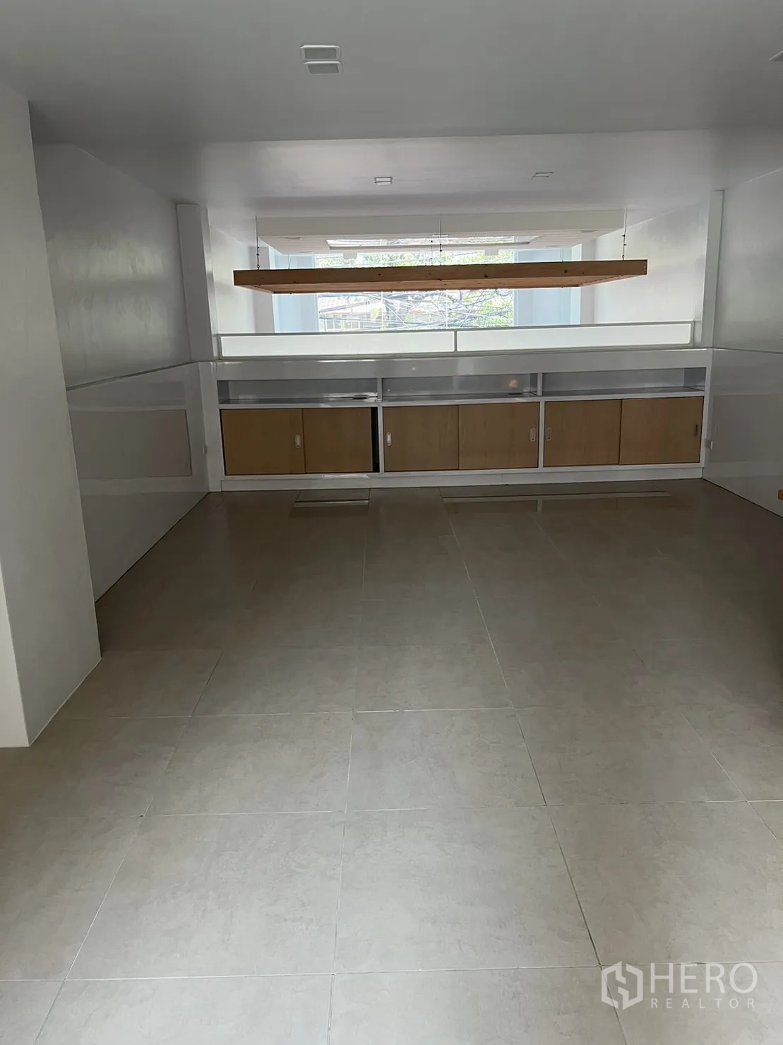 Shophouse for rent in Watthana, Bangkok - Back room or mezzanine with built-in cabinets and large floor tiles.