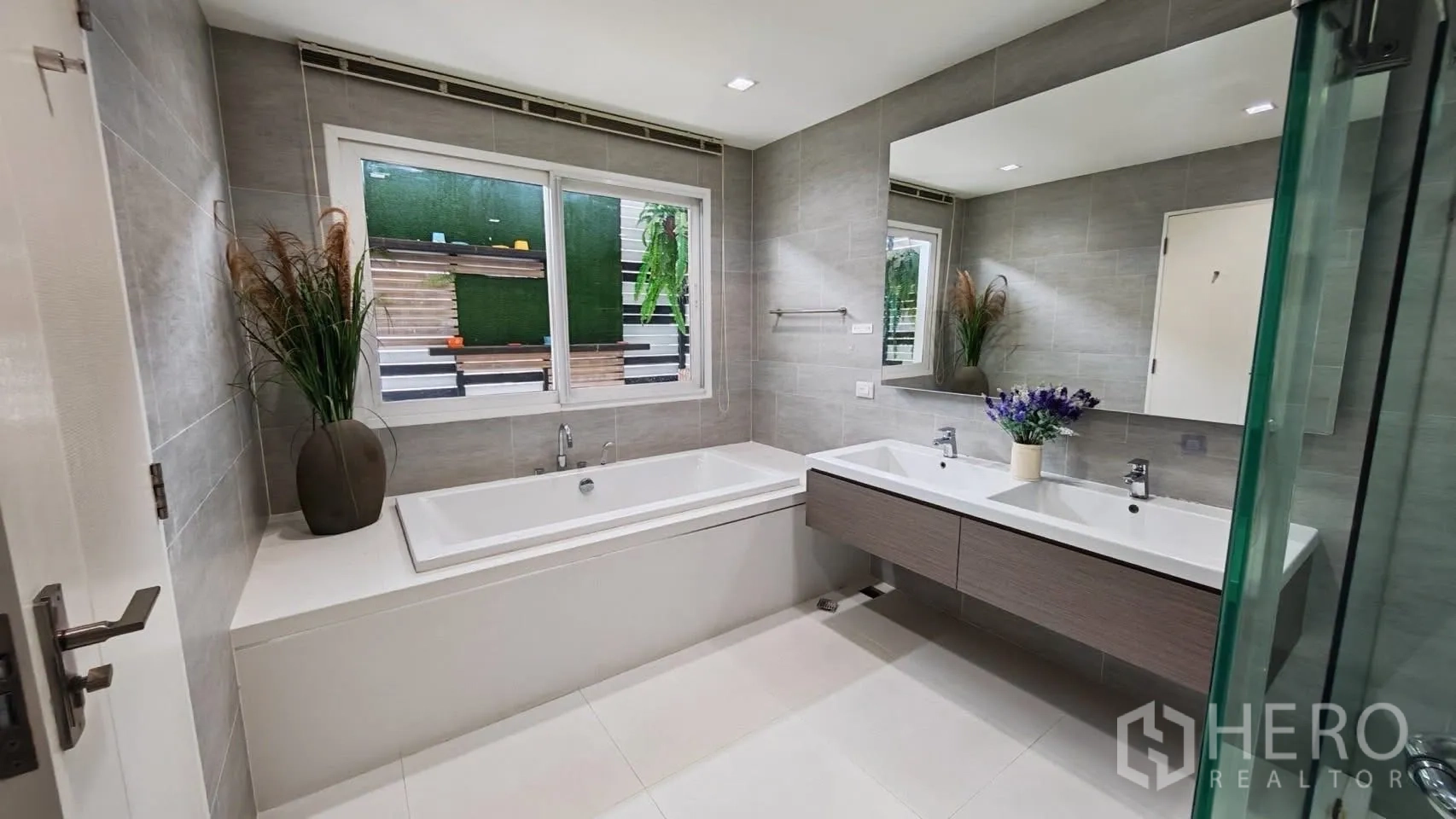 Detached House for rent or sale in Bang Phli, Samut Prakan - Modern bathroom with a soaking tub, double vanity, and a window bringing in natural light.