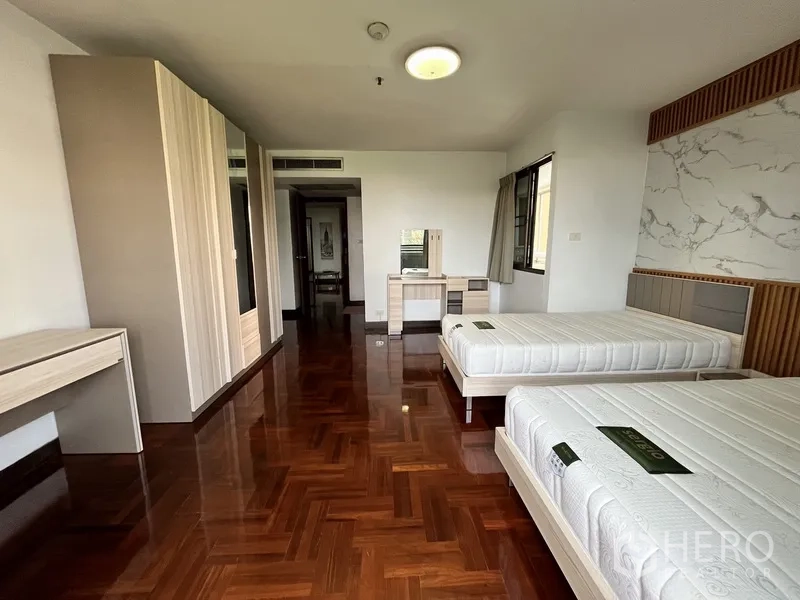 Condominium for rent in Watthana, Bangkok - Second angle of twin bedroom showing wardrobes, dressing table and parquet floor.