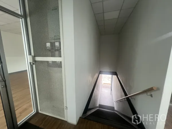 พื้นที่ขายปลีก ให้เช่า - บันไดพร้อมราวจับเชื่อมขึ้นสู่ชั้นพื้นที่ค้าปลีกและประตูกระจก