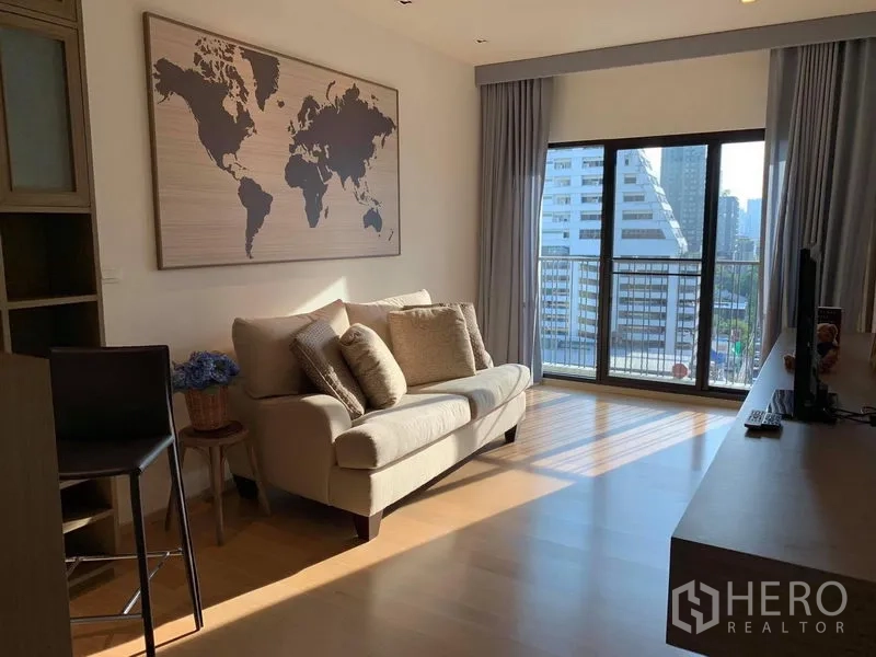 คอนโด ให้เช่าในPhaya Thai, Bangkok - โซนนั่งเล่นรับแสงธรรมชาติ โซฟาสีครีม ม่านทึบ และระเบียงหันสู่สกายไลน์