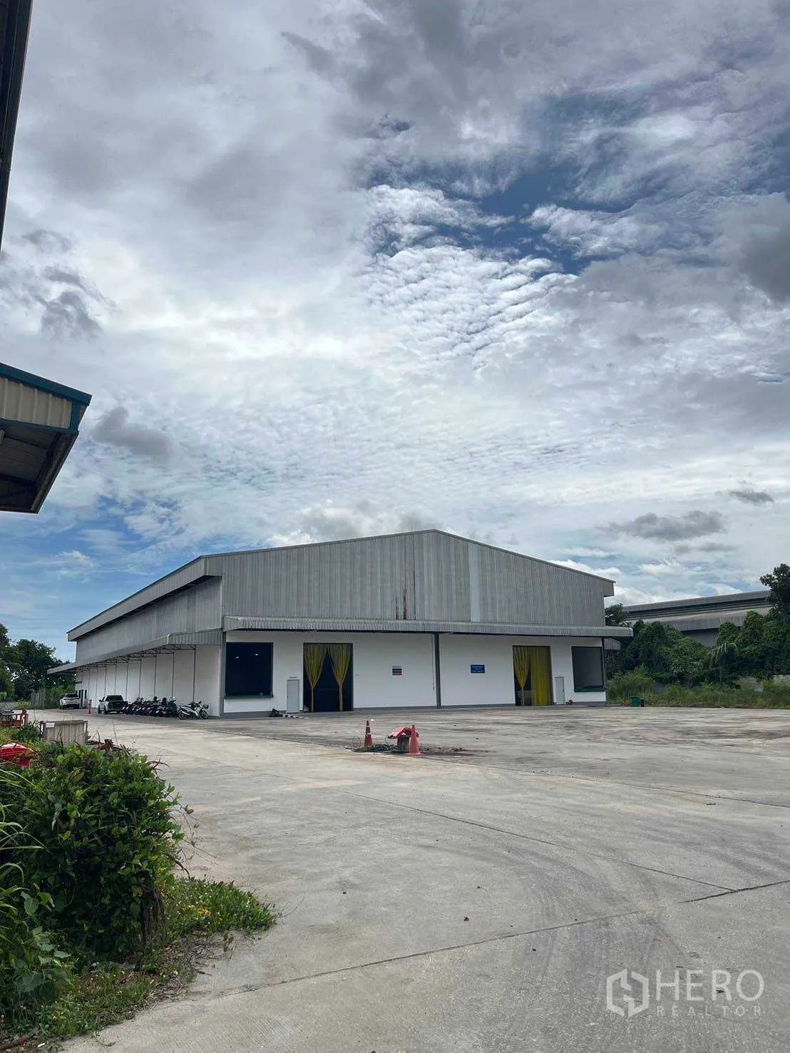 工厂 出售在Nikhom Phatthana, Rayong - 仓库正面，带装卸雨棚与宽大混凝土广场。