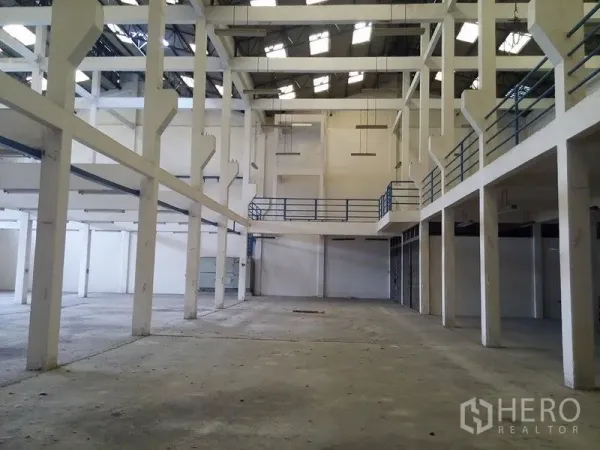 Warehouse for rent in Min Buri, Bangkok - Spacious warehouse interior with high clear height, white columns and mezzanine railings in Min Buri, Bangkok.