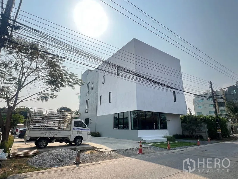 สำนักงานที่บ้าน ให้เช่าหรือขายในThanyaburi, Pathum Thani - ภาพภายนอกโฮมออฟฟิศสีขาว 3 ชั้น สมัยใหม่ มีที่จอดรถและถนนหน้าอาคาร