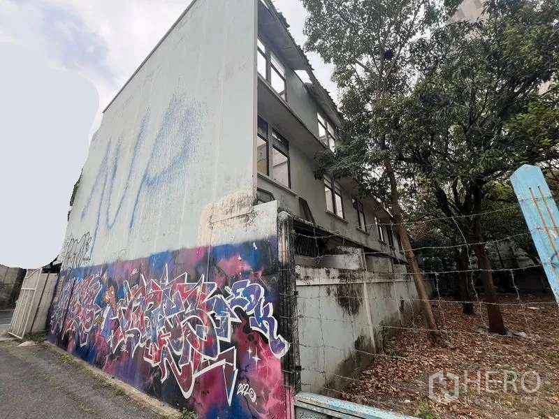 ที่ดิน ให้เช่าในWatthana, Bangkok - ผนังด้านข้างมีกราฟฟิติ ถัดจากซอยมีรั้วและต้นไม้ใหญ่