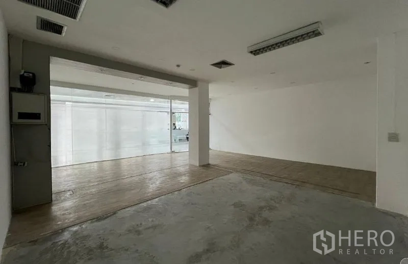 พื้นที่ขายปลีก ให้เช่า - ภายในร้านแบบเปิดโล่ง ผนังสีขาว ช่องแอร์ และหน้ากระจกพร้อมปรับตกแต่ง