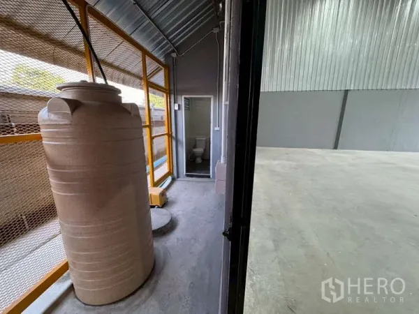货栈 出租在Bang Phli, Samut Prakan - 仓库旁服务走道，设蓄水罐与金属网栏