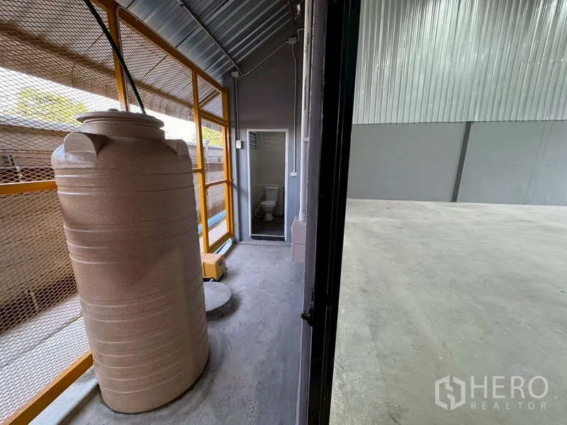 货栈 出租在Bang Phli, Samut Prakan - 仓库旁服务走道，设蓄水罐与金属网栏