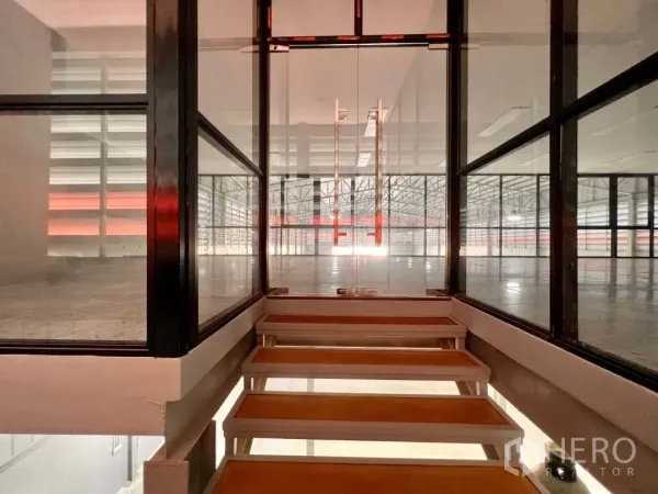 货栈 出租在Sai Mai, Bangkok - 通往夹层办公室的玻璃楼梯走道，可俯瞰仓库作业区。