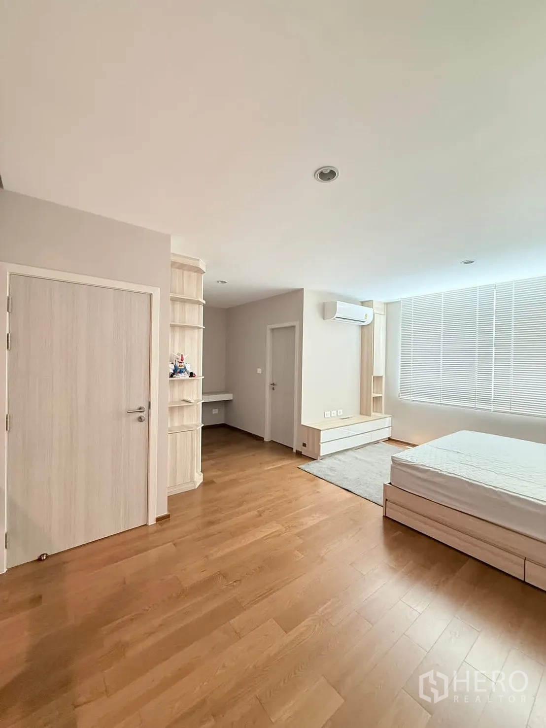 Townhouse for rent in Saphan Sung, Bangkok - Spacious bedroom with bed, wood flooring and air conditioner.