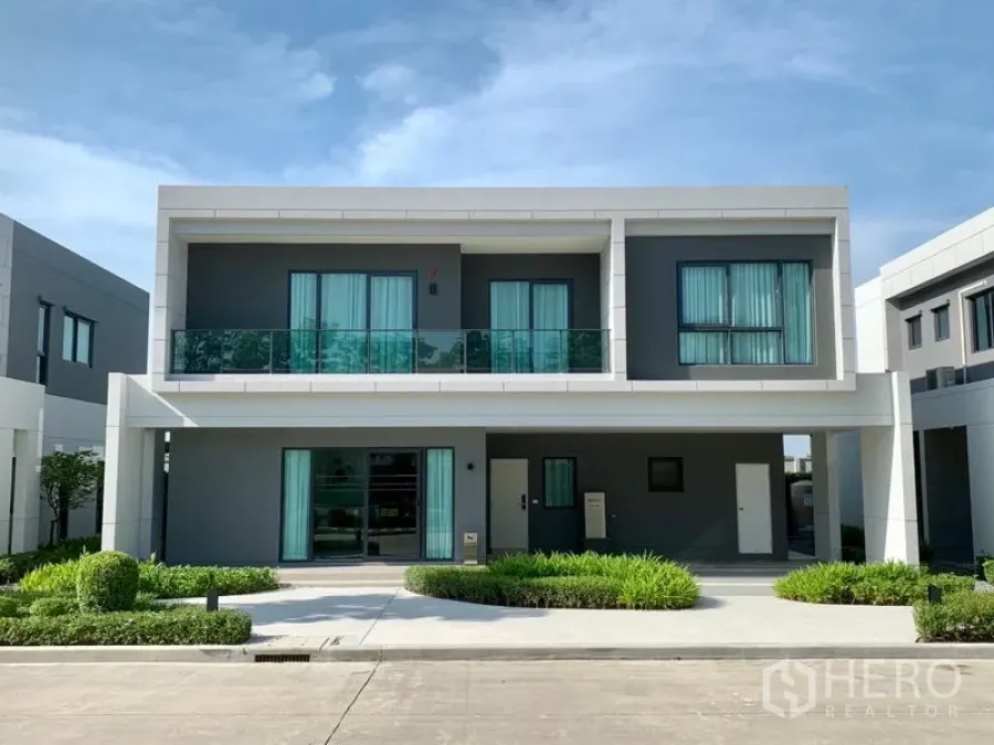 Detached House for sale - Contemporary two-storey house exterior with balconies, grey-and-white facade, driveway, carport and landscaped garden.