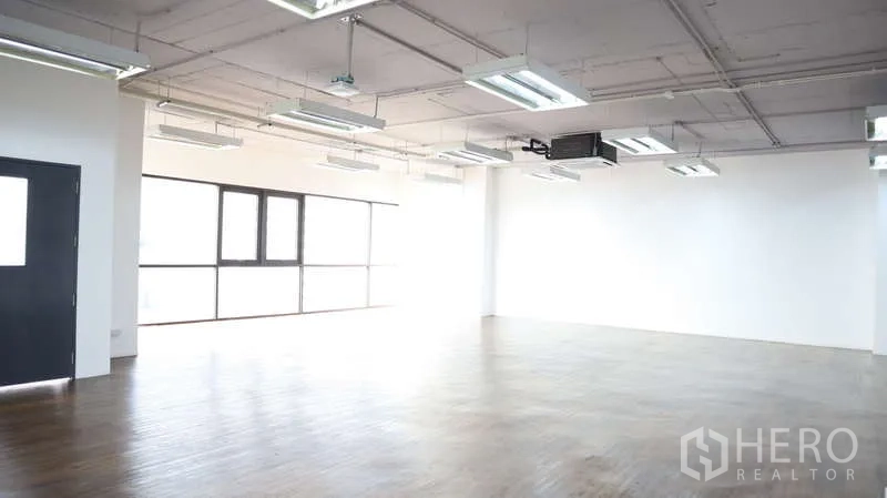 สำนักงาน ให้เช่า - พื้นที่ออฟฟิศแบบเปิดโล่ง เพดานลอย โคมไฟแขวนหลายชุด และหน้าต่างบานใหญ่