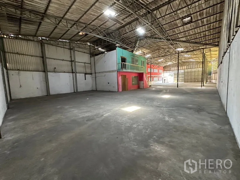 Warehouse for rent in Suan Luang, Bangkok - Deep warehouse area with concrete floor, side offices and a wide shutter at the far end.