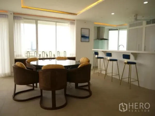 คอนโด ให้เช่าในKhlong Toei, Bangkok - โต๊ะอาหารทรงกลมและเคาน์เตอร์บาร์พร้อมสตูลสีน้ำเงินข้างหน้าต่างบานใหญ่