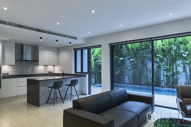 ทาวน์เฮาส์ ขายในWatthana, Bangkok - ครัวและห้องนั่งเล่นเปิดสู่สระกระเบื้องสีน้ำเงินและดาดฟ้าไม้