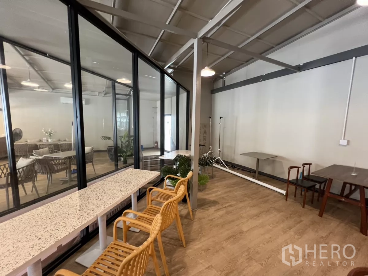 พื้นที่ขายปลีก ให้เช่าในKhlong Toei, Bangkok - ห้องกระจกติดผนังข้างพื้นที่นั่ง พื้นลายไม้และเก้าอี้หวาย สไตล์โมเดิร์น.