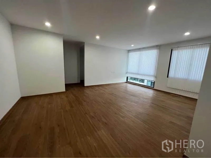 Home Office for rent in Bang Phli, Samut Prakan - Spacious room with wood-style flooring, recessed lighting and large windows with vertical blinds.