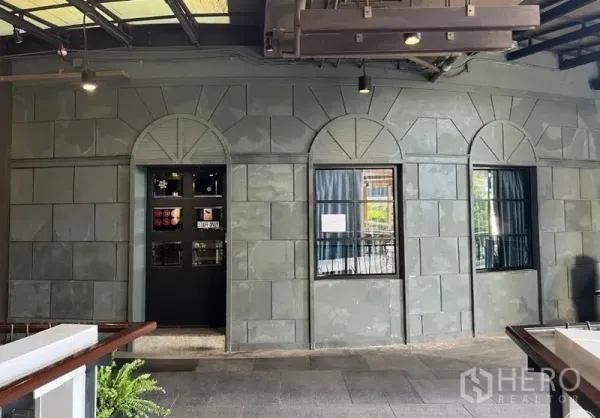 พื้นที่ขายปลีก ให้เช่า - ผนังลายหินพร้อมหน้าต่างโค้งและประตูทางเข้าในโถงทางเดินเปิดโล่ง