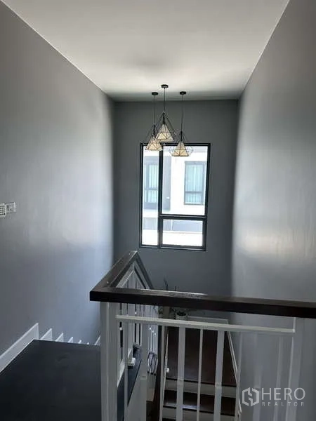 บ้าน ขายในLam Luk Ka, Pathum Thani - โถงบันไดพร้อมโคมแขวนดีไซน์โมเดิร์นและหน้าต่างสูง