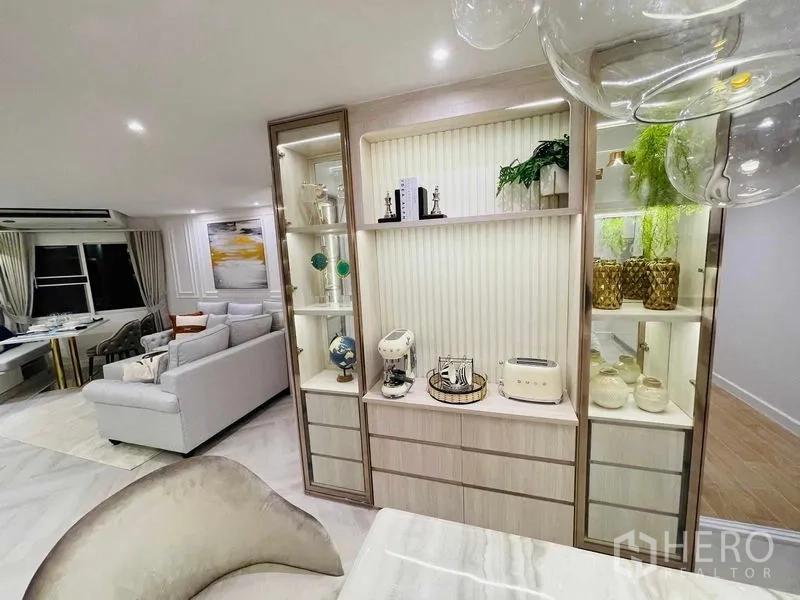 Condominium for sale in Yan Nawa, Bangkok - Built-in display shelves with decor pieces beside open-plan living area.