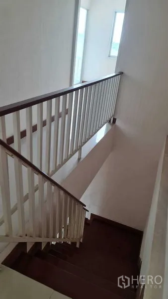 联排别墅 for 在Lam Luk Ka, Pathum Thani - 明亮楼梯间，白色扶手与木踏板，窗户采光。