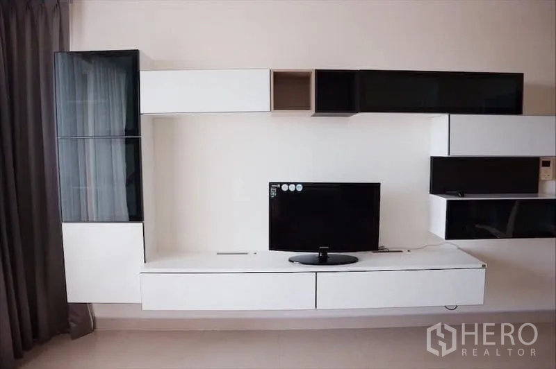 คอนโด ให้เช่าหรือขาย - ชั้นวางและตู้แขวนทีวีดีไซน์โมเดิร์นภายในห้องนั่งเล่น