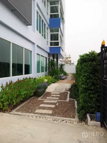 货栈 出租或出售在Bang Phli, Samut Prakan - 楼侧花园步道与灌木丛，临近大面积窗户。
