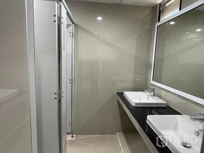 Office Space for rent in Bang Rak, Bangkok - Modern restroom with double sinks, large mirror and private cubicles.