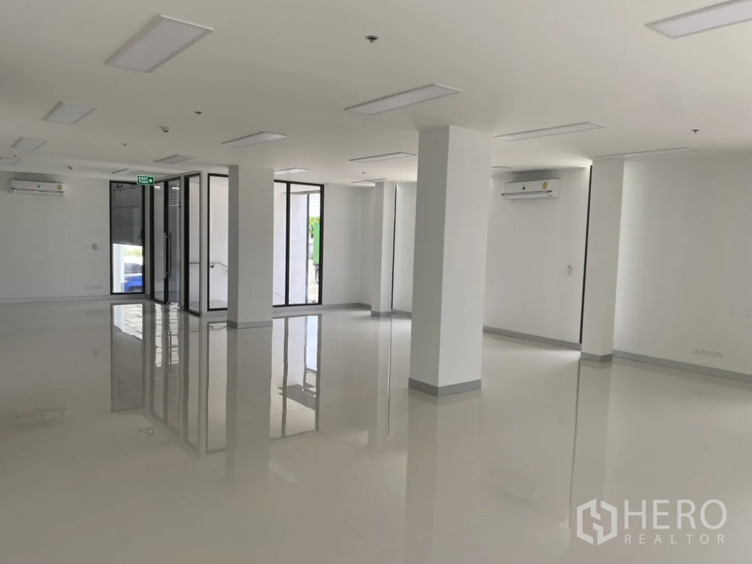 Warehouse for rent in Chachoengsao - Open office space showing air‑conditioning units, glass doors and glossy flooring.