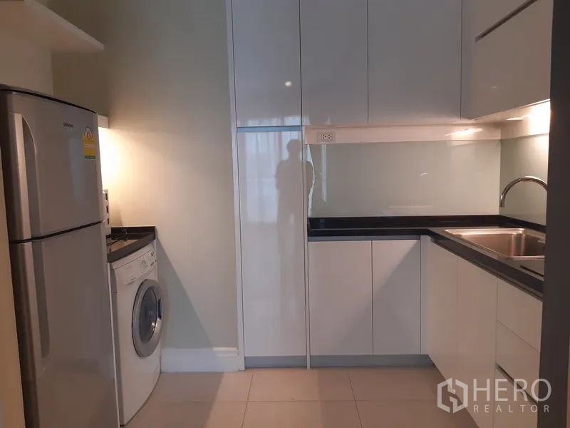 公寓 出租或出售在Khlong Toei, Bangkok - 现代U型厨房，白色亮面橱柜，水槽、冰箱与滚筒洗衣机