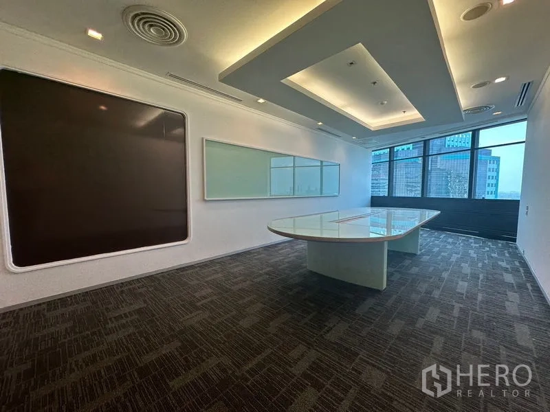 办公空间 出租在Khlong Toei, Bangkok - 会议室，靠窗椭圆玻璃桌与白板。