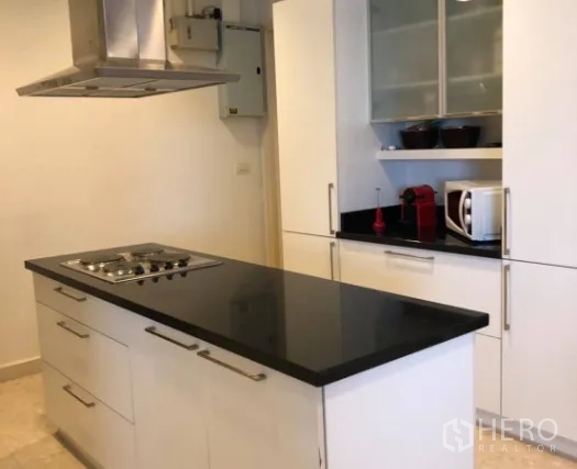 公寓 出售在Khlong Toei, Bangkok - 现代白色厨房，黑色花岗岩中岛与燃气灶及排烟机