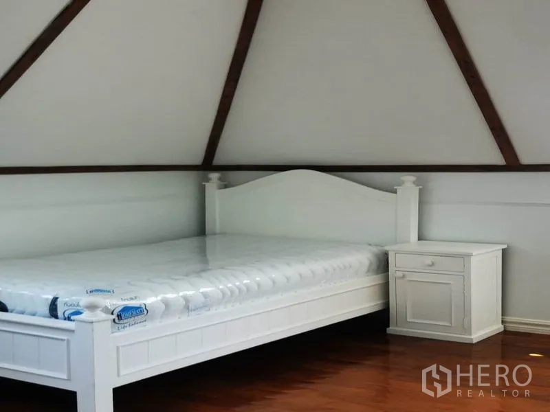 独立式住宅 出租在Mueang Samut Prakan, Samut Prakan - 斜屋顶卧室，白色床架与床头柜