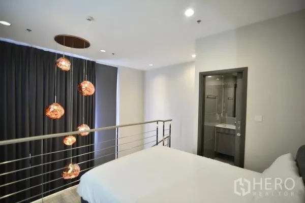 公寓 出租在Huai Khwang, Bangkok - 夹层卧室带套内卫浴，金属扶手与多头吊灯