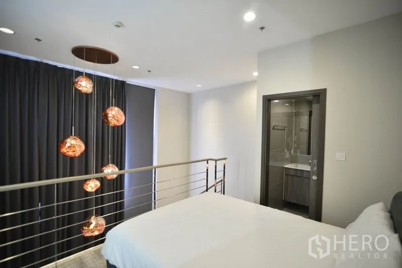 公寓 出租在Huai Khwang, Bangkok - 夹层卧室带套内卫浴，金属扶手与多头吊灯