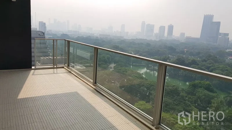 Condominium for rent in Pathum Wan, Bangkok - High-floor balcony corner showing treetop and lake views of the central park.