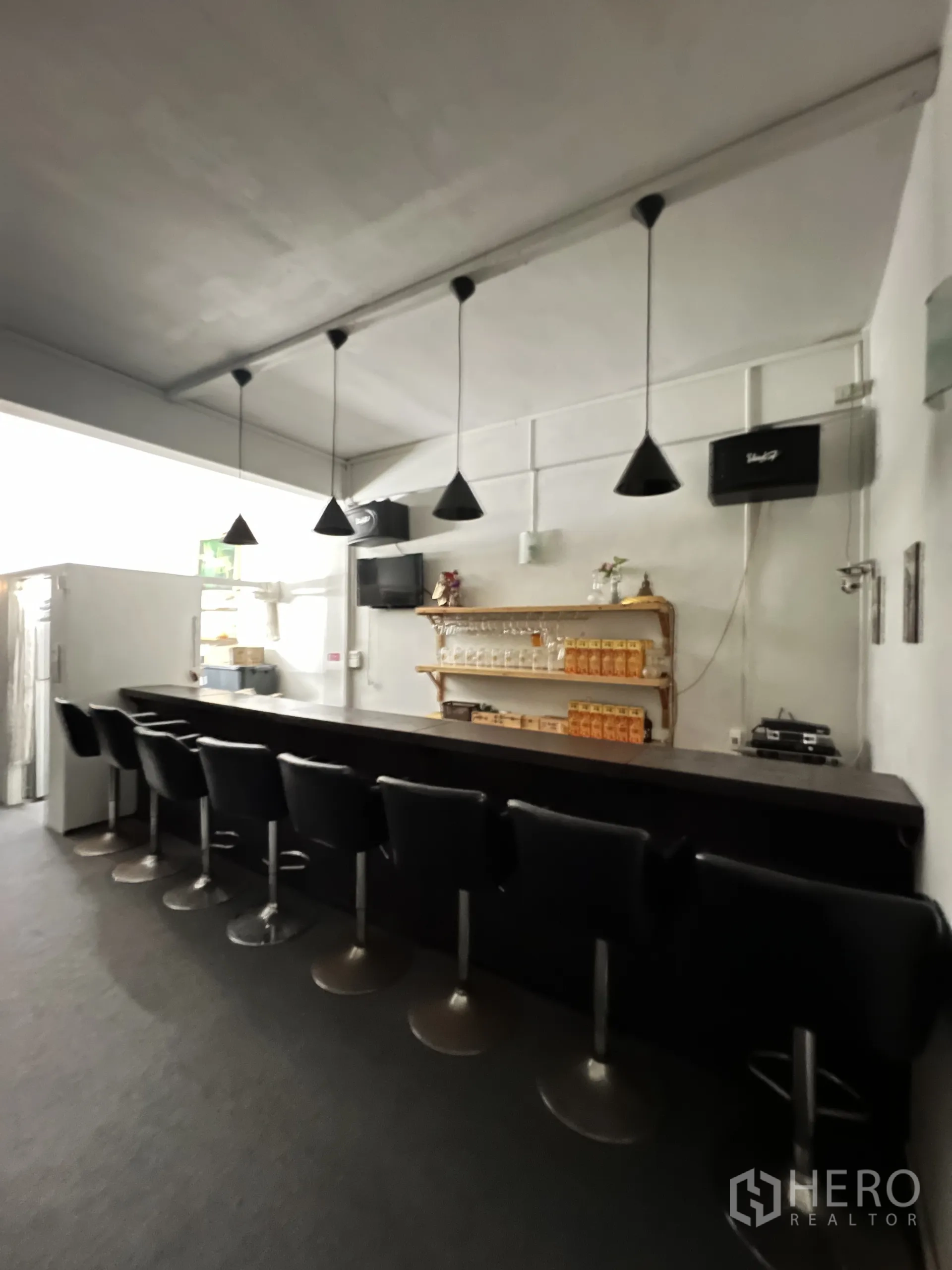 店屋 出租在Khlong Toei, Bangkok - 明亮吧台区，成排吧椅、锥形吊灯与玻璃杯置物架。