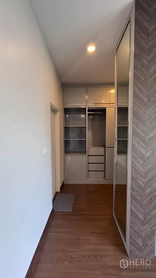 บ้าน ให้เช่าหรือขายในSaphan Sung, Bangkok - พื้นที่แต่งตัวมีตู้เสื้อผ้าบานกระจกเงาและชั้นวางแบบเปิดตลอดแนวทางเดิน.