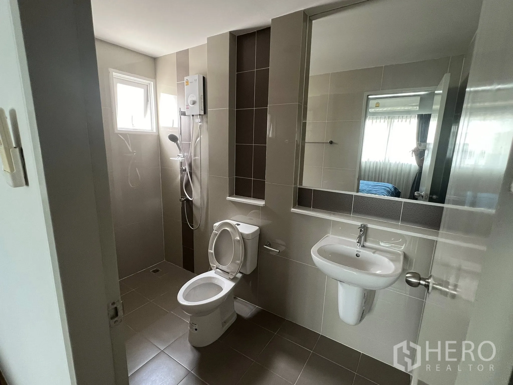 Detached House for rent or sale in Don Mueang, Bangkok - Bright bathroom with shower, toilet and wall mirror.