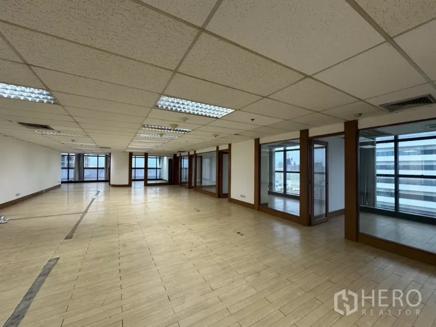 Office Space for rent in Watthana, Bangkok - Spacious open-plan office with wood-look flooring, glass-partitioned rooms and city views through large windows.