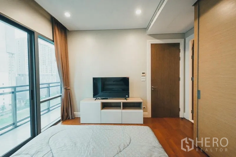 คอนโด ให้เช่าในKhlong Toei, Bangkok - มุมทีวีในห้องนอนหลักตรงข้ามเตียง พร้อมประตูสู่ห้องน้ำในตัว